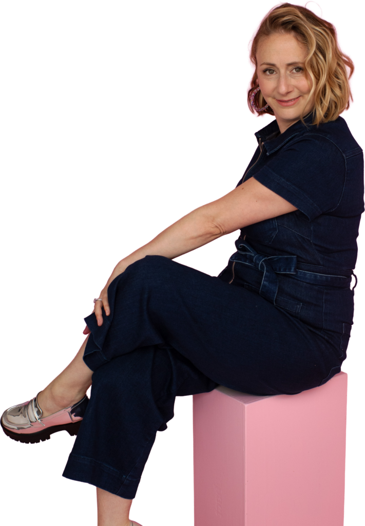 Alissa smiling at camera sitting on pink box